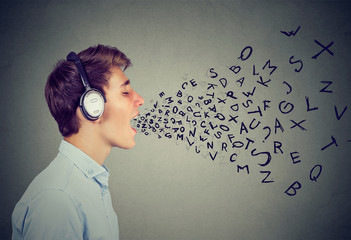 Teen in headphones singing on gray