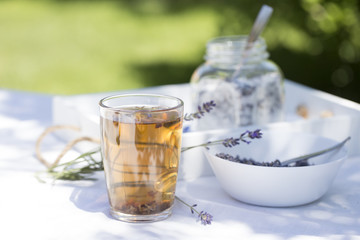 Herbal lavender tea in glass cup with lavender flowers