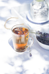 Herbal lavender tea in glass cup with lavender flowers