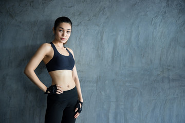 Close up asian beautiful sport girl on wall of gym,Thailand love health,Slim woman workout concept,show six pack