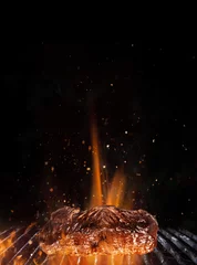  Tasty beef steak on cast iron grate with fire flames. © Lukas Gojda