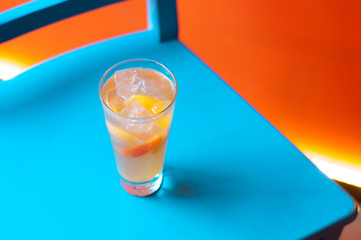 Orange juice on blue wooden background, top view. Closeup glass of cocktail