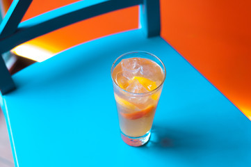 Orange juice on blue wooden background, top view. Closeup glass of cocktail