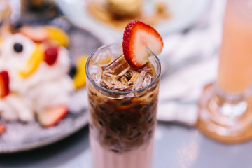 Iced Strawberry Milk with one shot of espresso and served with a slice of strawberry. 
