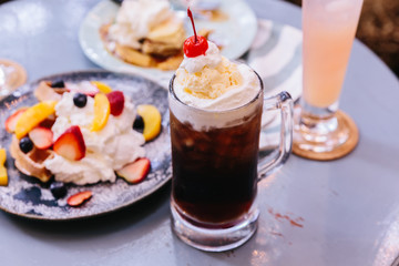 Sweet refreshing Cherry Cola topping with a scoop of vanilla ice cream and fresh cherry.
