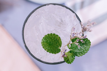 Top view of lime soda with mint leaves and flowers on the top.
