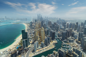 Aerial view of modern skyscrapers and sea in the background in Dubai, UAE.