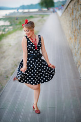 A girl in a dress is dancing happily in the outside