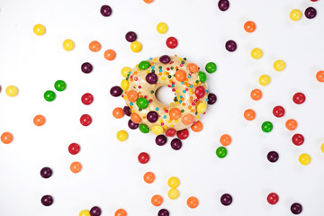 Appetizing golden donut sprinkled with colorful chocolate pellets.
