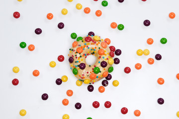 Appetizing golden donut sprinkled with colorful chocolate pellets.