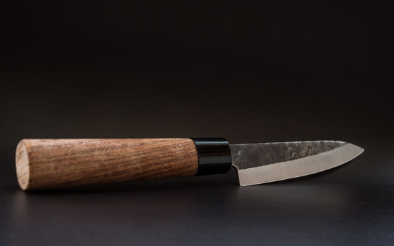 wooden knife on a black leather surface
