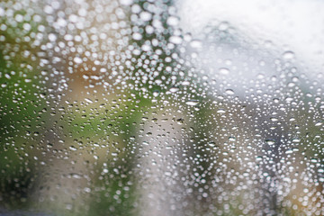 Rain drops on window glasses surface with cloudy background . Natural Pattern of raindrops isolated on cloudy background.