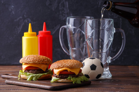 Photo of two hamburgers, glasses, soccer ball, ketchup