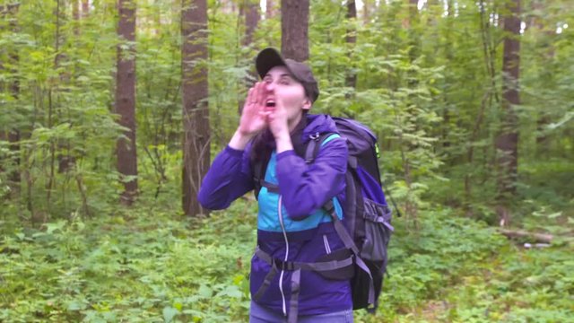 confused woman in panic with backpack, lost in the woods calling for help