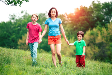 Fototapeta premium Children walk with their mother across the field.
