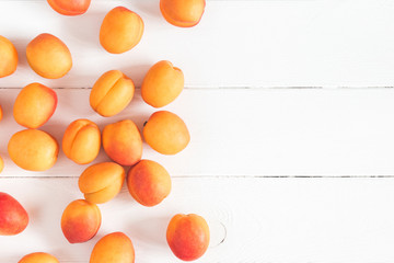 Apricots on white wooden background. Flat lay, top view, copy space