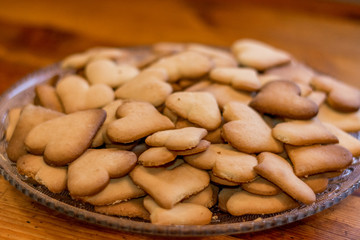 Ready-made festive shortbread cookies in the shape of hearts for Christmas and Valentine's Day, lie on a glass dish