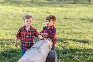 Two cute brother boys tweens having fun outside at sunset in the country