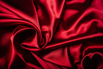 Red fabric in the folds. drapery. shine on silk. Sewing