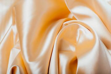 Gold fabric in the folds. drapery. shine on silk. Sewing