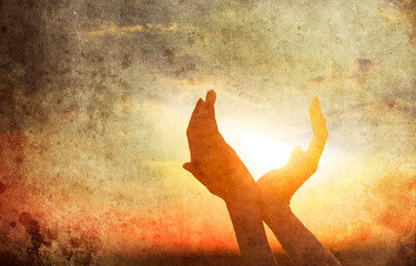 hands holding the sun at dawn. Image made in vintage style