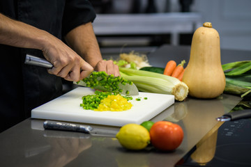 Chef cutting vegetables in a professional kitchen