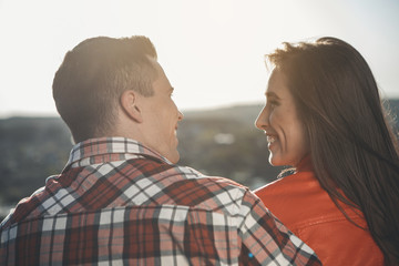 Sight of love. Profile of loving couple looking into each other eyes with wide joyful smiles on their faces. They are bonding to each other on summer nature