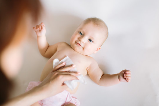 Hygiene - young momy wiping the baby skin with wet wipes. Cleaning wipe, pure, clean