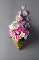 Fresh spring roses in waffle cone. Beautiful romantic background in flat lay style. Trendy hipster background.