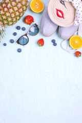 Palm branch, fruit, shoes and sunglasses, on a blue background, summer vacation. Free space for text. Copy space. Flat lay.