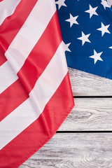 Patriotic flag of United States of America. USA flag placed on wooden background with copyspace, top view. Symbol of patriotism.