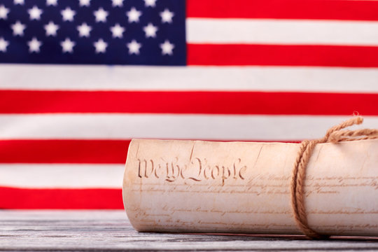 Close up Constitution of US on USA flag background. Declaration of Independence of the United States of America with american flag in the background.