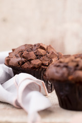 Homemade muffins with chocolate, vintage background.