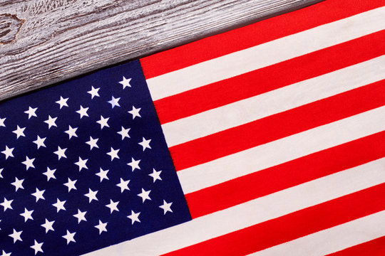 Close up flag of USA on wooden background. Cotton flag of United States of America on grey wood.