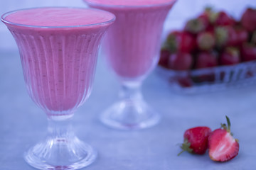 Strawberry smoothies in glass glasses on a gray background.
