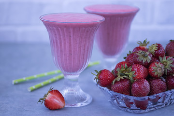 Strawberry smoothies in glass glasses on a gray background.