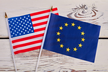 Small flags of USA and Europe. Cocktail flags of America and Europe on vintage wooden surface.