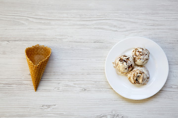 Ice cream in white plate with sweet cone, top view. Overhead, flat lay.