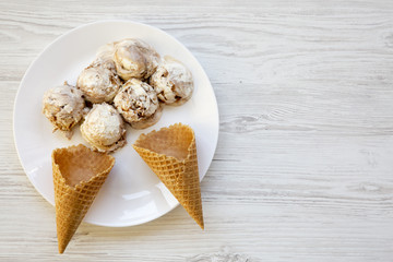 Top view, ice cream in white plate with sweet cones. From above, flat lay. Copy space.