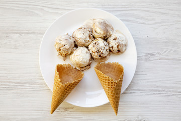 Top view, ice cream in white plate with sweet cones. From above, flat lay.  Close-up.