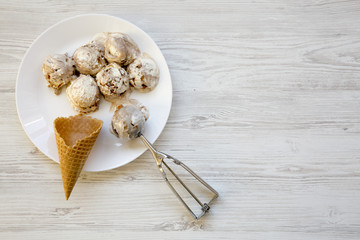 Ice cream in white round plate with sweet waffle cones and spoon for ice cream, top view. From above, flat lay. Space for text.