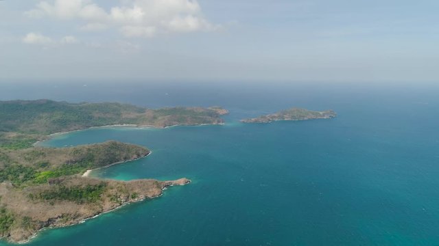 Aerial view of coast with beaches, island Limbones, lagoons and coral reefs. Neela cove, Philippines, Luzon. Coast ocean with turquoise water. Tropical landscape in Asia.