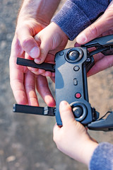 Father and son looking at remote control joystick and piloting quadrocopter