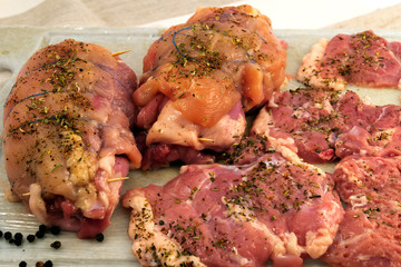 Slices of meat with seasoning from herbs and folded rolls of meat of different sorts, fixed with...