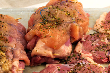 Meat roll for baking, fixed with wooden sticks and blue thread to keep the shape.