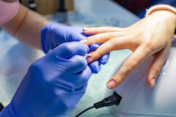The master does a manicure in the salon