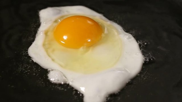 One Egg is Fried In A Frying Pan In sunflower Oil - close up view