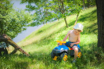 The child sits on a child car among the nature
