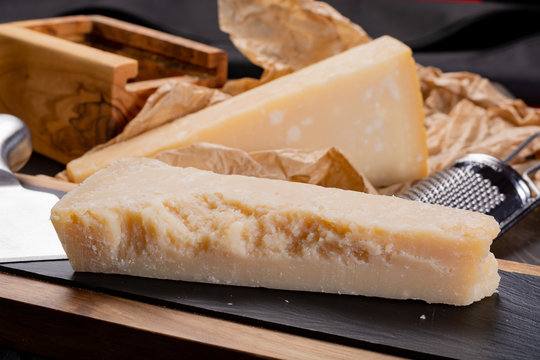 Aged Italian parmesan hard cheese Parmigiano-Reggiano with cheese knife
