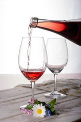 Rose wine served with two glasses and flowers copy space close up